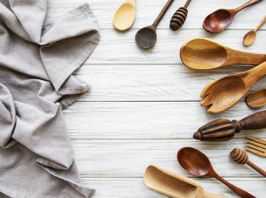 Eski mutfak gereçleri. Tahta kaşıklar, peçete. Beyaz ahşap masanın üzerinde. Üst görünüm