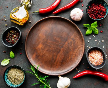 Boş ahşap tabaklar, baharatlar, otlar ve sebzelerden oluşan bir çerçeve. Üst manzara, düz uzanma.