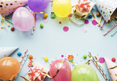 Mutlu yıllar ya da parti geçmişi. Doğum günü balonları, konfeti ve kurdeleler mavi arka planda. Üst Manzara. Boşluğu kopyala.