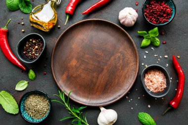 Boş ahşap tabaklar, baharatlar, otlar ve sebzelerden oluşan bir çerçeve. Üst manzara, düz uzanma.