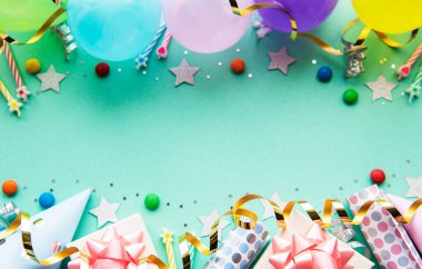 Mutlu yıllar ya da parti geçmişi. Doğum günü balonları, konfeti ve pastel yeşil arka planda kurdeleler. Üst Manzara. Boşluğu kopyala.