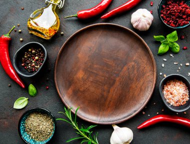 Boş ahşap tabaklar, baharatlar, otlar ve sebzelerden oluşan bir çerçeve. Üst manzara, düz uzanma.