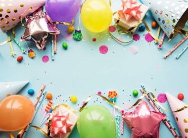 Mutlu yıllar ya da parti geçmişi. Doğum günü balonları, konfeti ve kurdeleler mavi arka planda. Üst Manzara. Boşluğu kopyala.