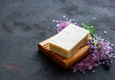 Organik sabun ve koyu beton arka planda bir buket taze lavanta çiçeği.