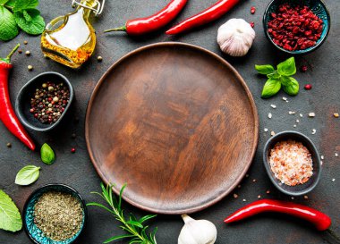 Boş ahşap tabaklar, baharatlar, otlar ve sebzelerden oluşan bir çerçeve. Üst manzara, düz uzanma.