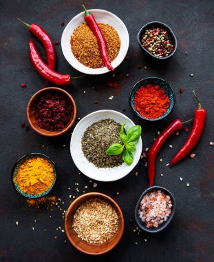 Siyah beton arka planda bir kasede çeşitli baharatlar. Üst görünüm kopyalama alanı.