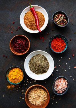 Siyah beton arka planda bir kasede çeşitli baharatlar. Üst görünüm kopyalama alanı.