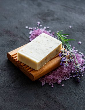Organik sabun ve koyu beton arka planda bir buket taze lavanta çiçeği.