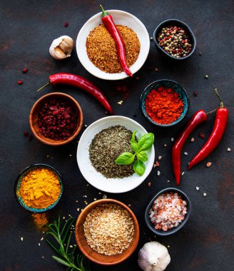 Siyah beton arka planda bir kasede çeşitli baharatlar. Üst görünüm kopyalama alanı.