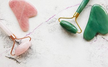 Güzellik masajı için yeşim yüz silindirleri. Mermer zemin üzerinde düz yatıyordu