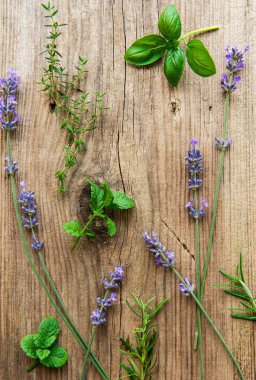 Eski ahşap arka planda lavanta çiçekleri ve taze bitkiler.