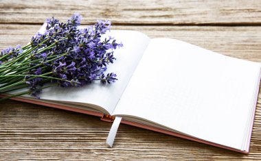 Lavanta buketi ve eski ahşap arka planda boş bir defter.