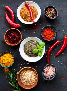 Siyah beton arka planda bir kasede çeşitli baharatlar. Üst görünüm kopyalama alanı.