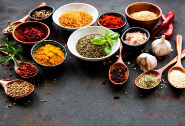 Siyah beton arka planda bir kasede çeşitli baharatlar. Üst görünüm kopyalama alanı.