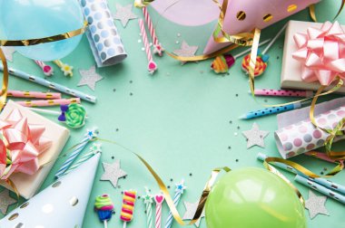 Mutlu yıllar ya da parti geçmişi. Doğum günü balonları, konfeti ve pastel yeşil arka planda kurdeleler. Üst Manzara. Boşluğu kopyala.