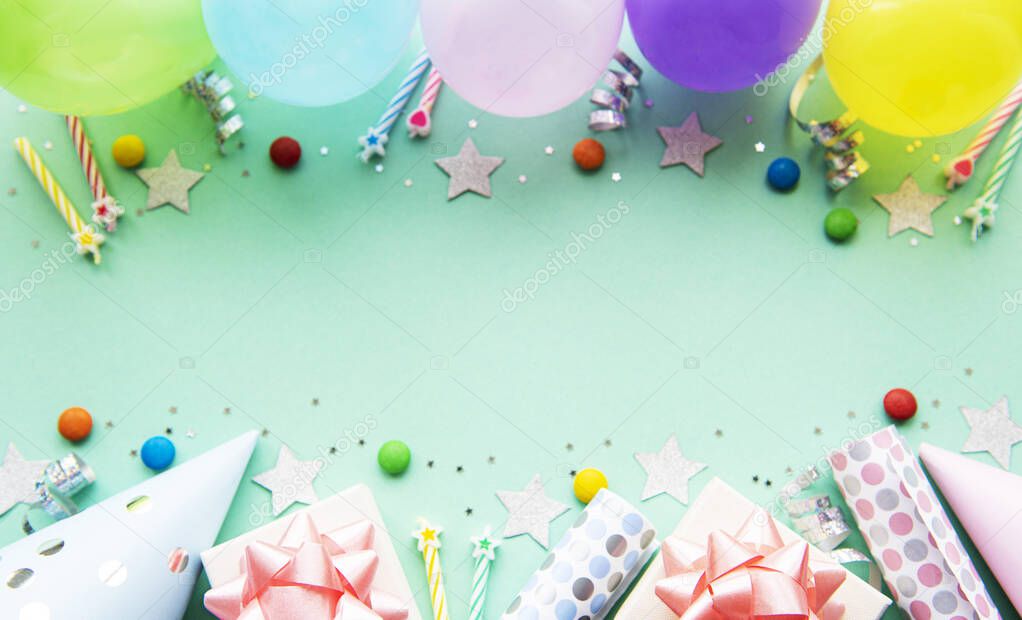 Happy birthday or party background.  Flat Lay wtih birthday balloons , confetti and ribbons on pastel green background. Top View.  Copy space.