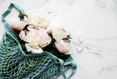 Beyaz mermer arka planda ip torbasında pembe şakayık. Düz yatıyordu