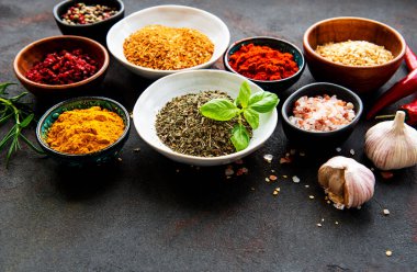 Siyah beton arka planda bir kasede çeşitli baharatlar. Üst görünüm kopyalama alanı.