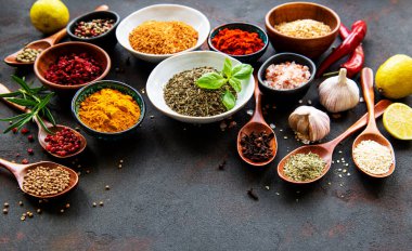 Siyah beton arka planda bir kasede çeşitli baharatlar. Üst görünüm kopyalama alanı.