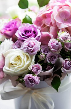 Güzel çiçekler. Pencere kenarında beyaz yuvarlak bir kutuda pembe ortanca ve güller.