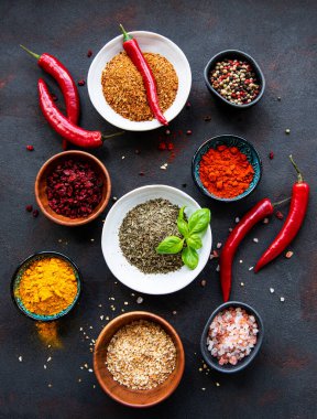 Siyah beton arka planda bir kasede çeşitli baharatlar. Üst görünüm kopyalama alanı.