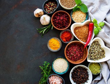 Siyah beton arka planda bir kasede çeşitli baharatlar. Üst görünüm kopyalama alanı.