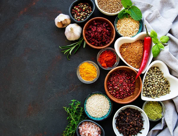 Siyah beton arka planda bir kasede çeşitli baharatlar. Üst görünüm kopyalama alanı.