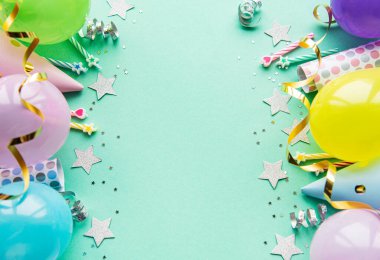 Mutlu yıllar ya da parti geçmişi. Doğum günü balonları, konfeti ve pastel yeşil arka planda kurdeleler. Üst Manzara. Boşluğu kopyala.