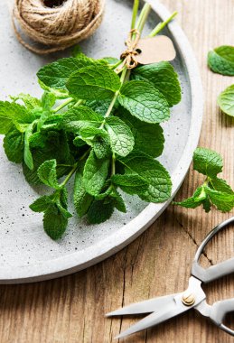 Eski ahşap masadaki taze yeşil nane yaprakları.