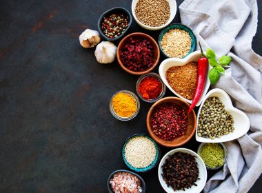 Siyah beton arka planda bir kasede çeşitli baharatlar. Üst görünüm kopyalama alanı.