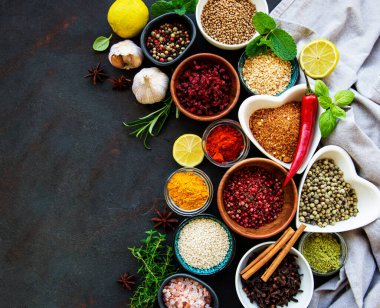 Siyah beton arka planda bir kasede çeşitli baharatlar. Üst görünüm kopyalama alanı.