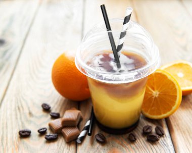 Eski ahşap arka planda portakal ve kahve kokteyli.