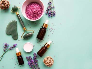 Lavantalı doğal organik SPA kozmetik. Düz banyo tuzu, spa ürünleri ve yeşil arka planda lavanta çiçekleri. Cilt bakımı, güzellik tedavi konsepti