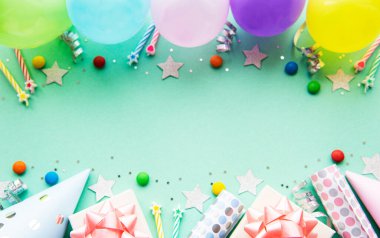 Mutlu yıllar ya da parti geçmişi. Doğum günü balonları, konfeti ve pastel yeşil arka planda kurdeleler. Üst Manzara. Boşluğu kopyala.
