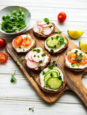 Sağlıklı sebzeli sandviçler ve ahşap bir masada mikro yeşiller.