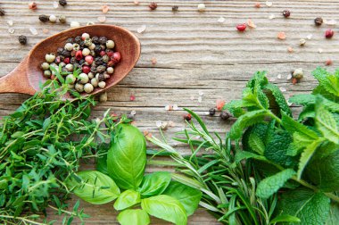 Ahşap arka planda taze otlar ve baharatlar.