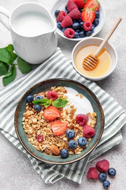 Granola ve taze meyve sağlıklı bir kahvaltı veya dokulu bir arka planda atıştırmalık hazırlar.