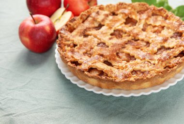 Lezzetli ev yapımı elmalı turta ve taze kırmızı elmalar, samimi bir sonbahar sahnesi yaratıyor.