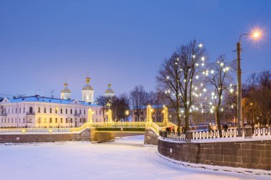Noel tatilinde St. Petersburg 'da. Krasnogvardeysky Köprüsü, Griboyedov ve Kryukov Kanalları 'nın kesişimindeki St. Nicholas Katedrali yakınlarındaki akşam aydınlığında. Rusya