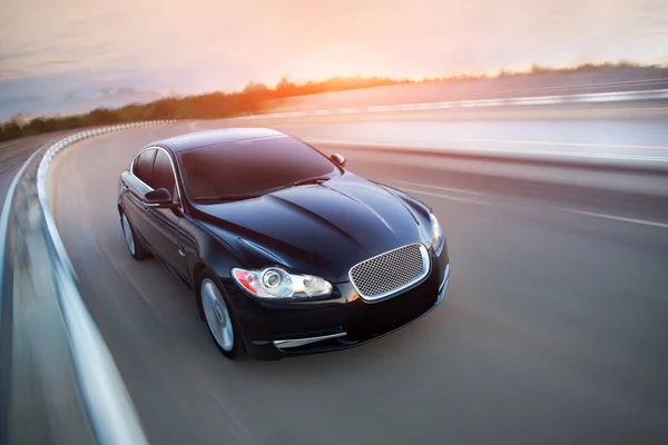 Siyah lüks araba yolda gidiyor. Gün batımında bulanık yol