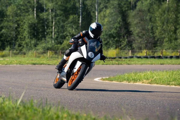 Motosikletli bir sürücü yolda tepe noktasında döner.