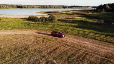 Toprak yolda giden turuncu araba. Hava görünümü