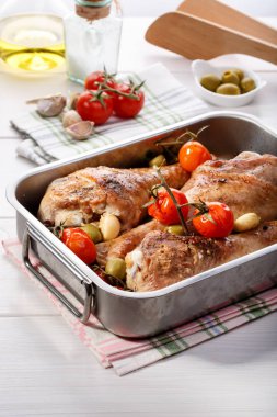 Kiraz domates, yeşil zeytin ve sarımsak ile kavrulmuş Türkiye baget. Beyaz masa üzerinde tava pişirme ızgara hindi budu.