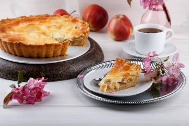 Beyaz ahşap masa üzerinde ev yapımı krem elmalı turta.