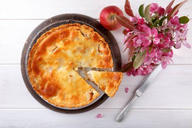 Beyaz ahşap masa üzerinde ev yapımı krem elmalı turta.