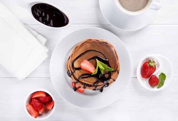 Stack of chocolate pancakes with chocolate topping and strawberr — Stock Photo, Image