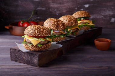 Ahşap masa üzerinde dört ev yapımı hamburger.