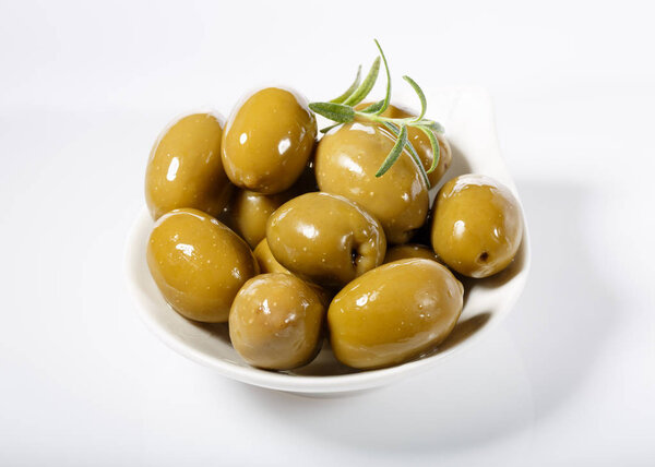 Whole green olives in white bowl