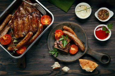 Izgara domuz pirzola ve sosis domates ve sos ile servis 