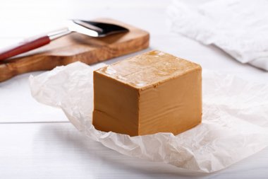 Norveçli brunost beyaz masada. Geleneksel İskandinav kahverengisi